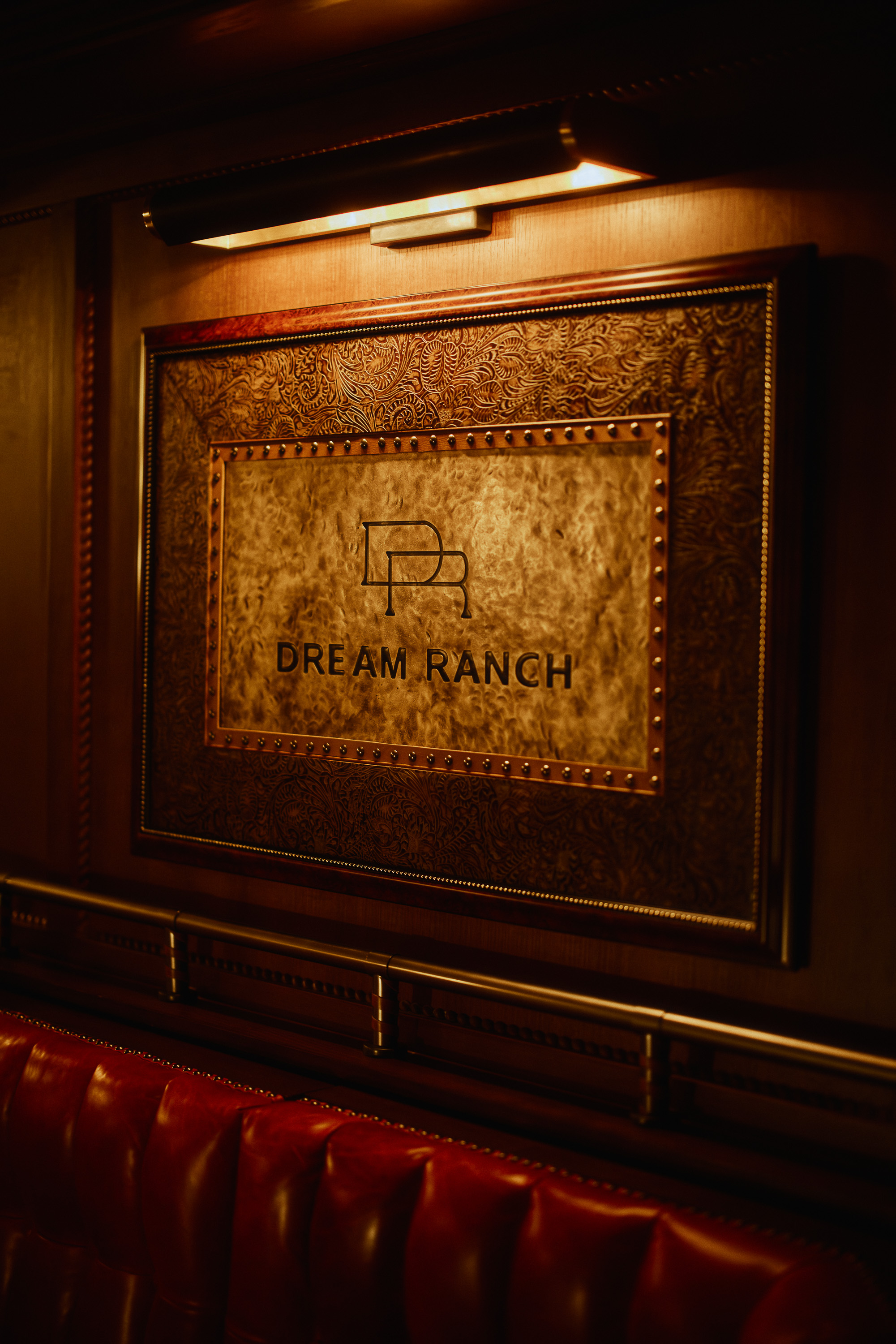 Framed ranch artwork above Cattlemen’s Club red leather seating