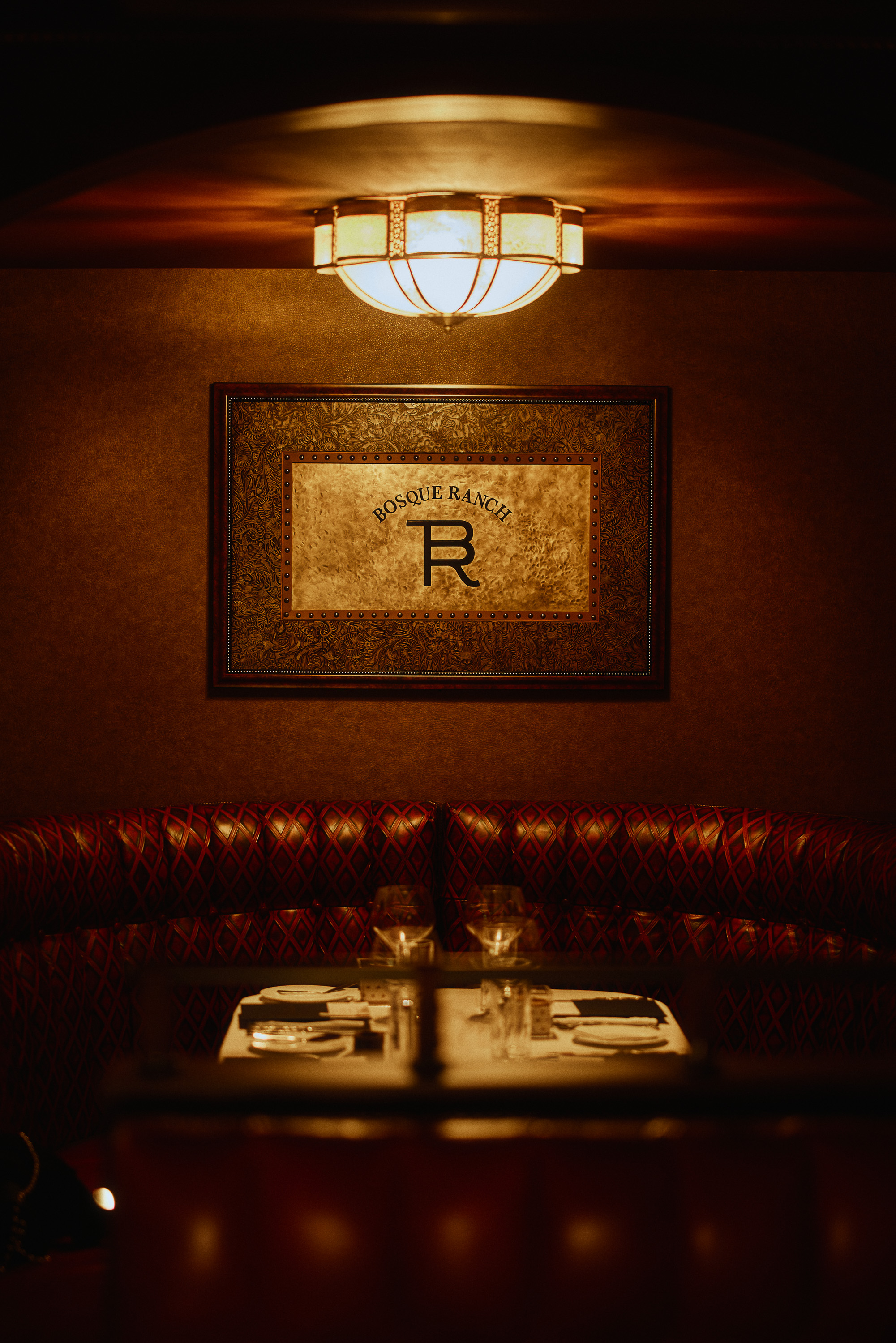 Cattlemen’s Club leather dining booth beneath a warm lamp